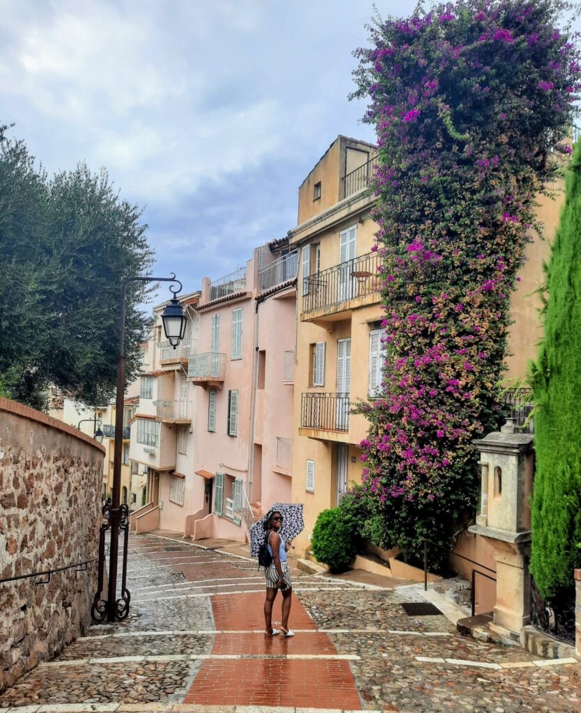 Colourful old town street in Le Suquet Cannes with pastel buildings and wet cobblestones on the French Riviera 