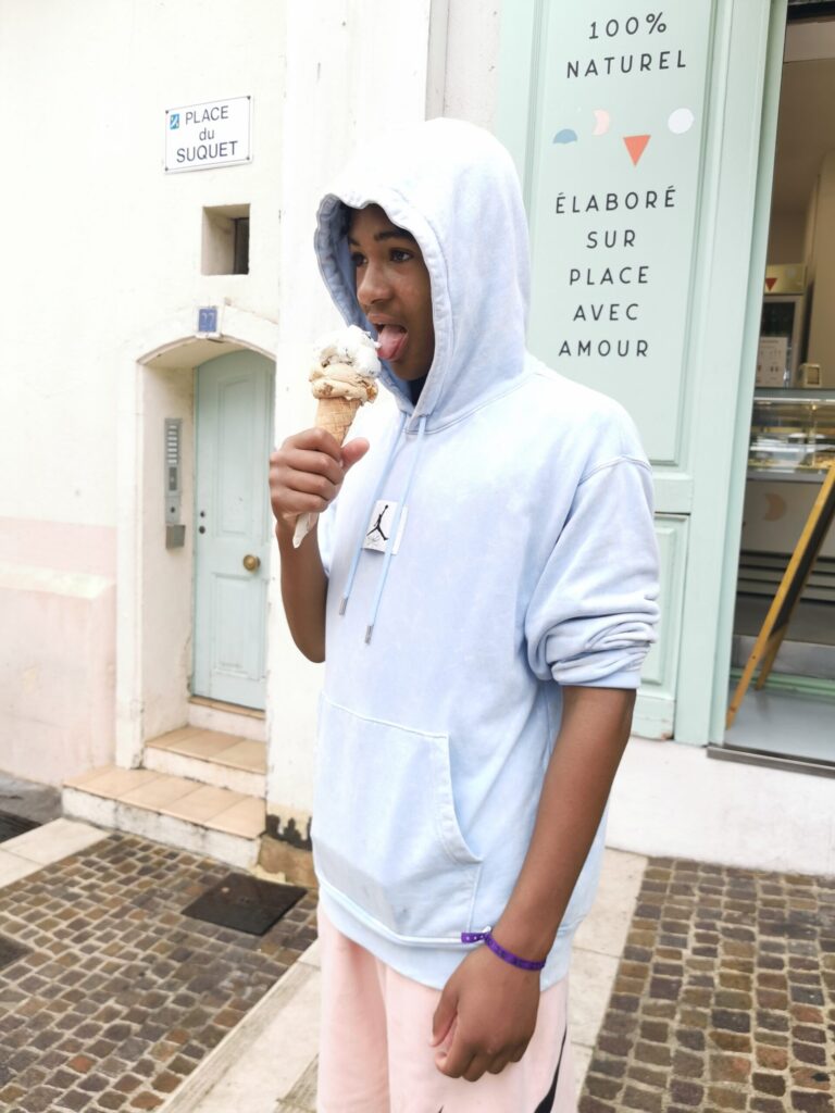 Teenager eating gelato outside La Gelateria Le Suquet Cannes on the French Riviera