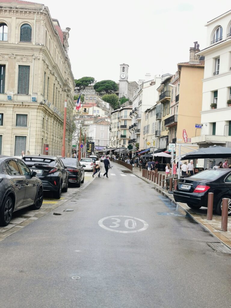 Street view in central Cannes with cafes and the Le Suquet hill in the background on the French Riviera 