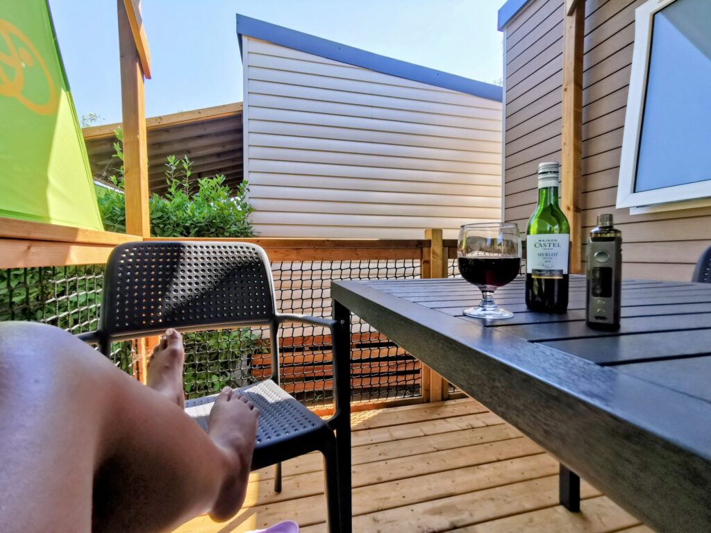 Private decking at a Eurocamp caravan in Frejus with outdoor seating, a glass of red wine and relaxed holiday setting.