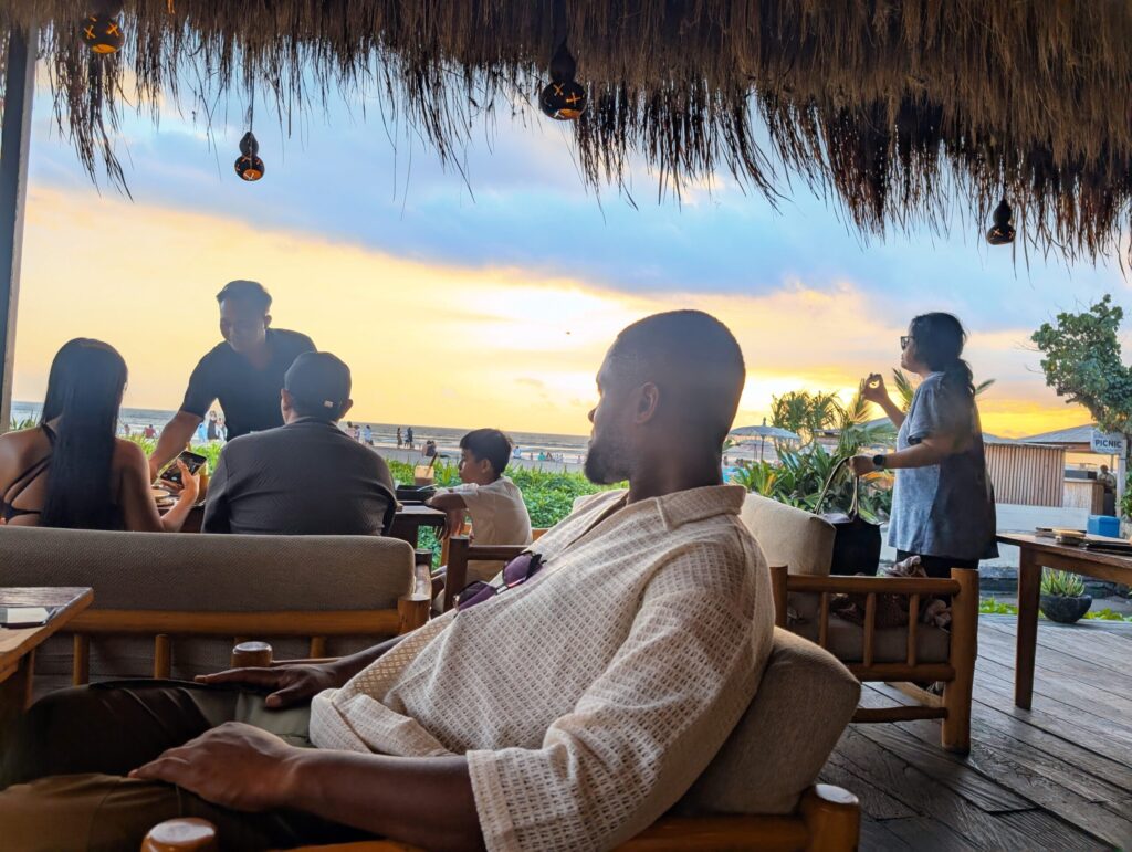 My husband relaxing at a beachfront restaurant at sunset in Bali.
