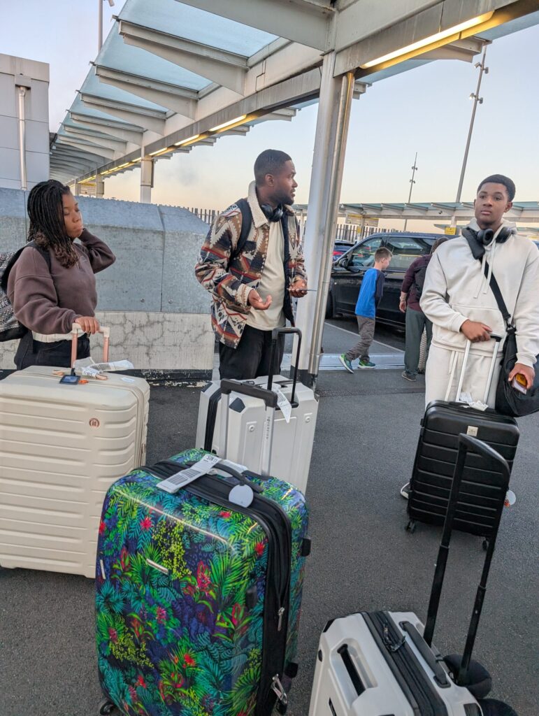 Family standing together with their suitcases whilst travelling .
