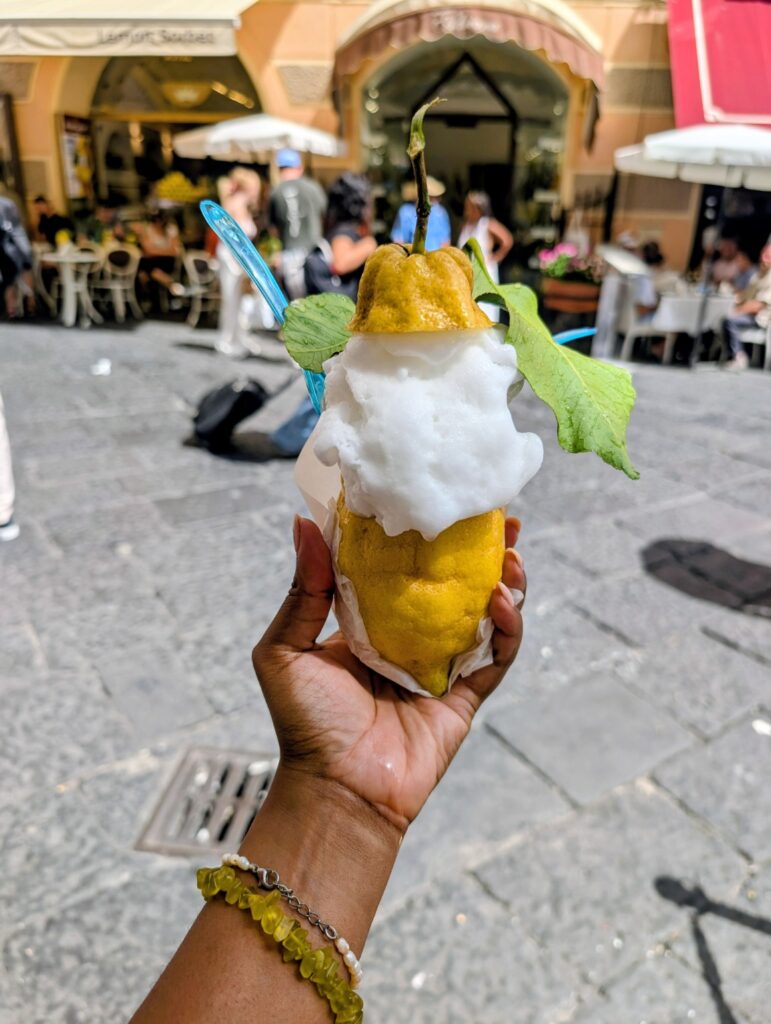 Lemon sorbet served inside a large lemon on a busy street in Amalfi, Italy.